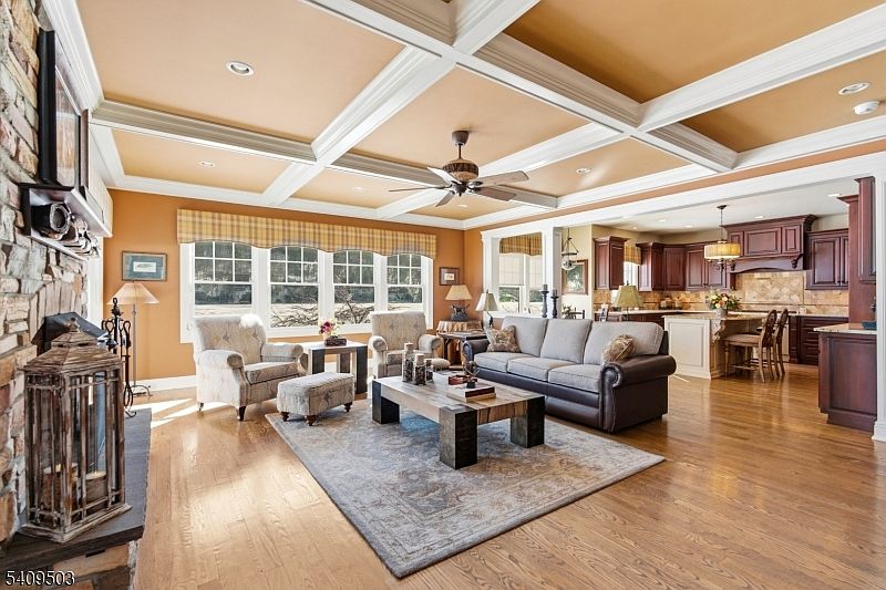 Open floor plan looking from the living room toward the cherry kitchen, with center island, breakfast nook, and large lake-view windows over the sink